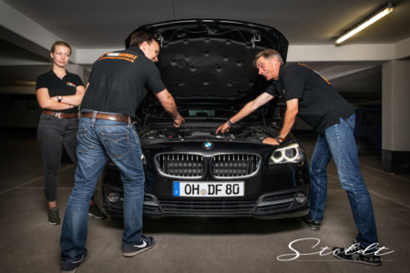Business photography driving school teachers discussing in front of a car